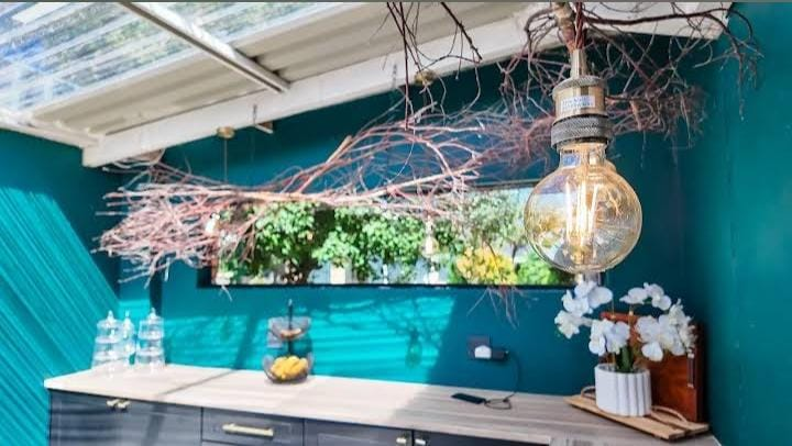 Teal breakfast counter with hanging Edison bulb
